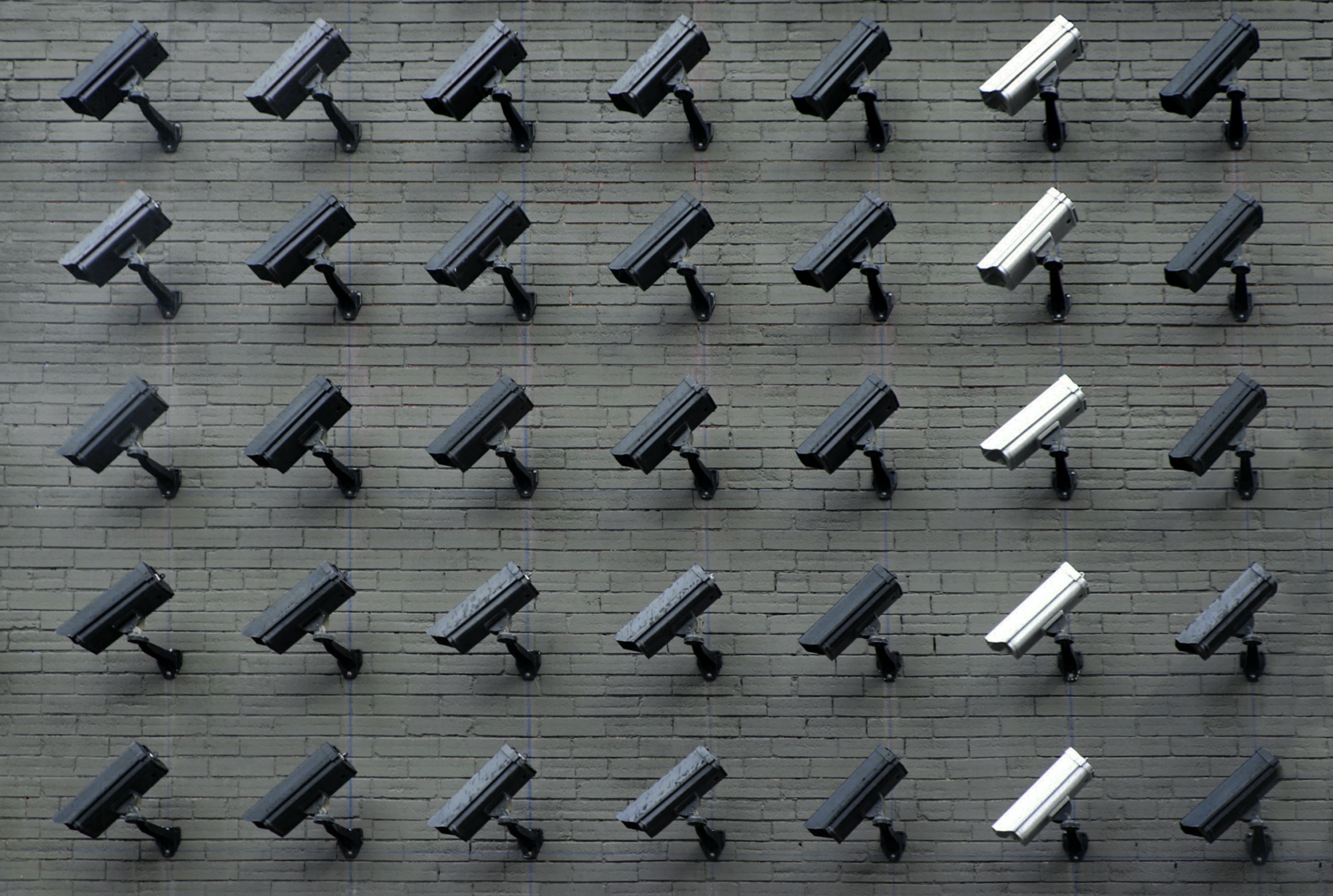 A wall of black and white security cameras. 