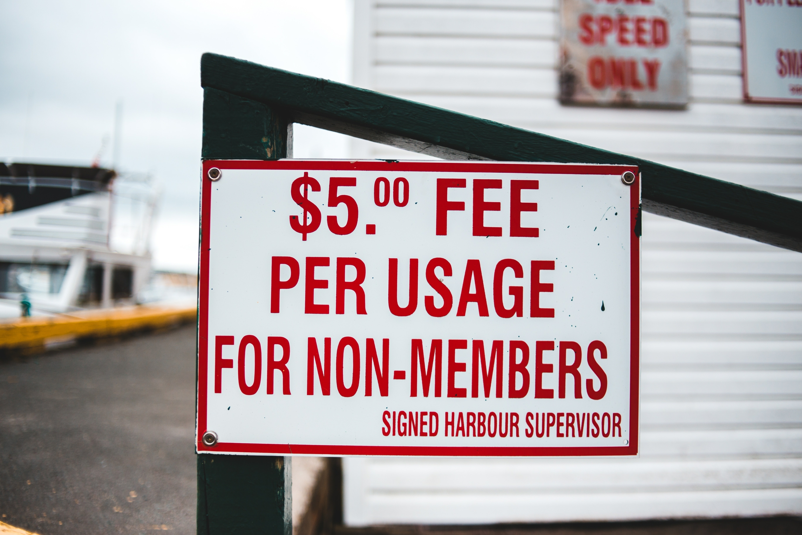 A decorative photo of a sign that says "$5 fee per usage for non-members." 