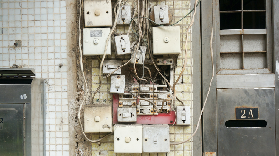 A disorganized set of power cords and switches plugged into what is decidedly too small of an outlet space.